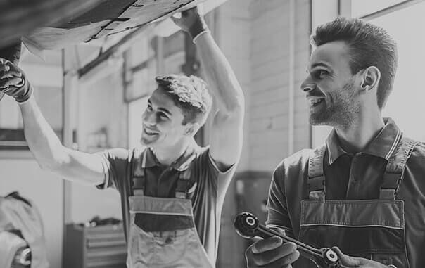 Two mechanics working on a car